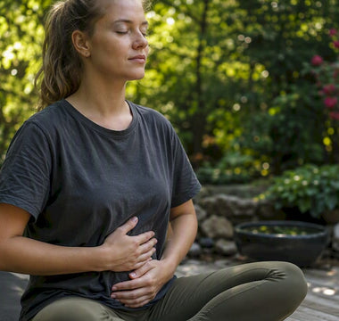 En person ligger på en yogamatta och fokuserar på djupa andetag.